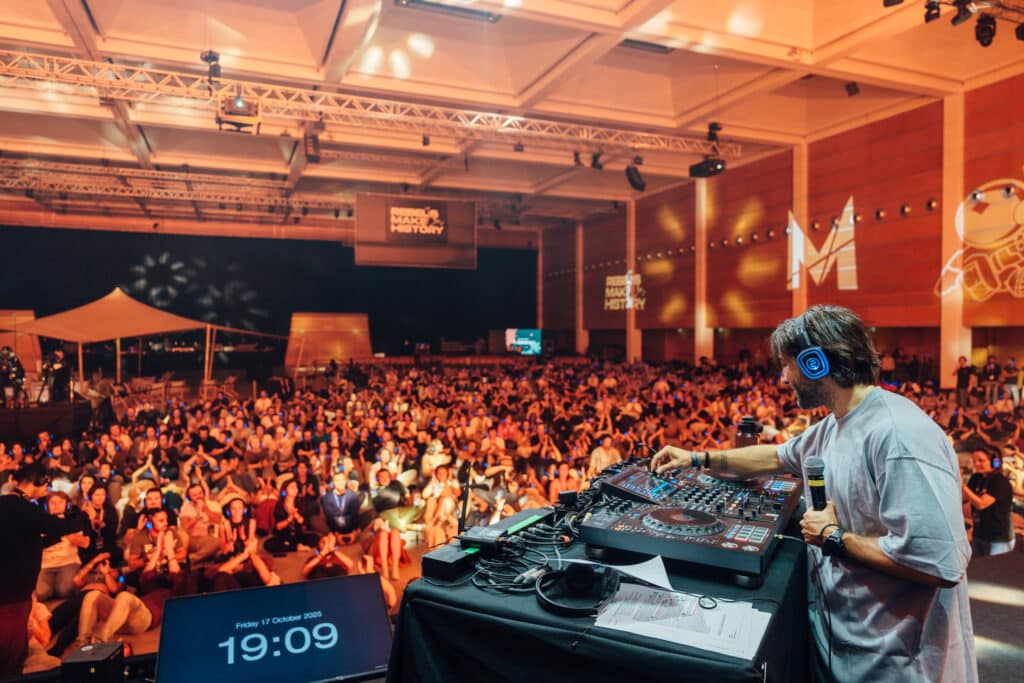DJ mit Silent Disco Kopfhörern vor einer grossen Menge mit Kopfhörern